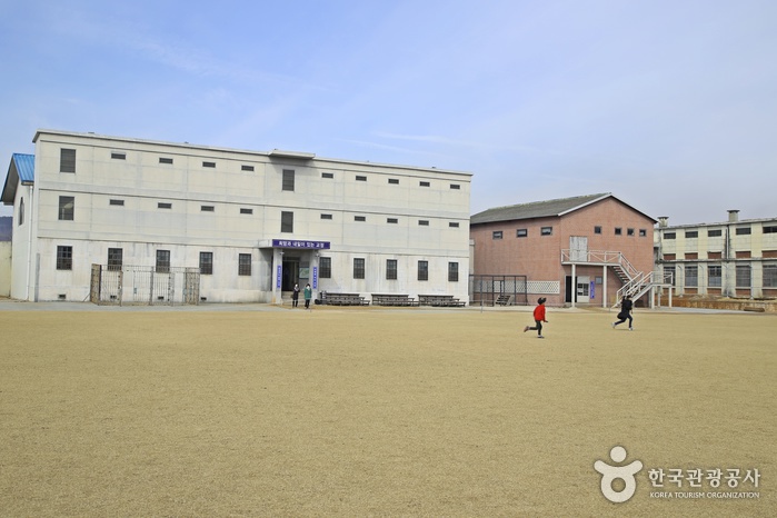 넓은 운동장 뒤로 교도소 건물이 실제처럼 보인다.