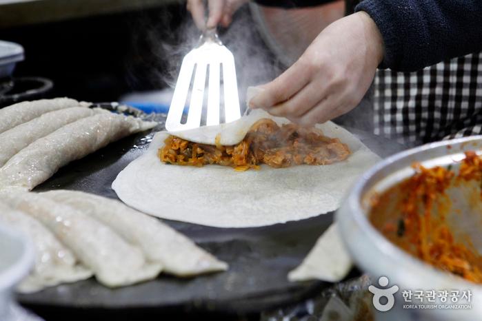 메밀전병에 볶은 김치와 당면 등으로 만든 소를 넣는다.