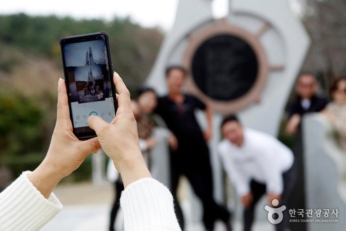 노래비 앞에서 기념사진을 찍는 사람들
