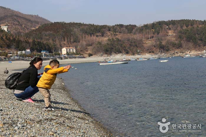 몽돌을 던지고 있는 검은모래해변의 아이